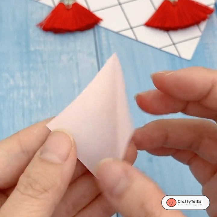 Step 2: Pressing the pentagon knot flat and folding the short tail inward into the fold crease