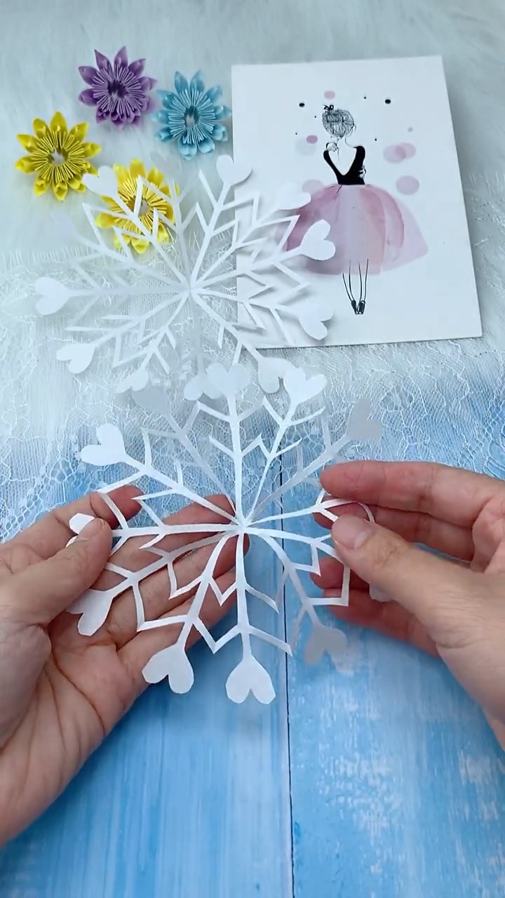 Step 6 Unfolding the Delicate Cut Paper Star to Reveal the Heart Tipped Snowflake