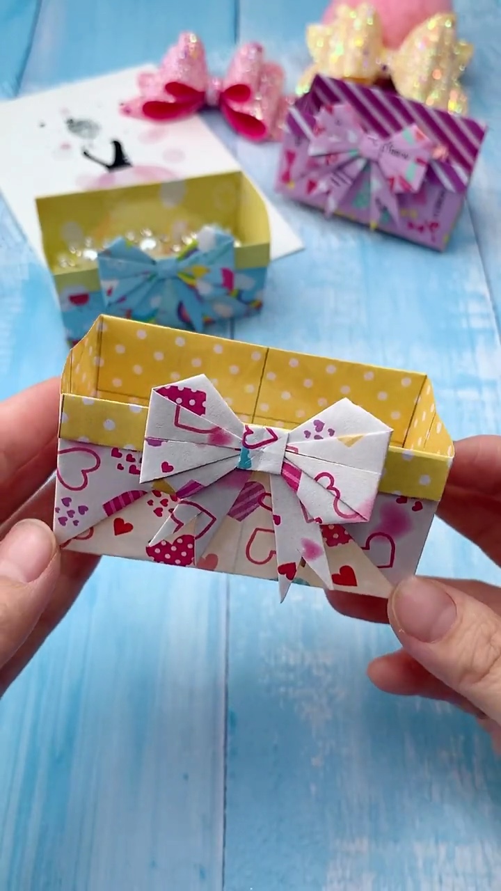 Step 6 Affixing Matching Folded Origami Ribbon Bow to Front Panel of Treat Basket