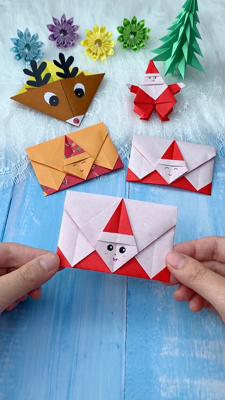 Handmade Origami Santa Envelopes Showing Front and Inside Pocket on Blue Wood